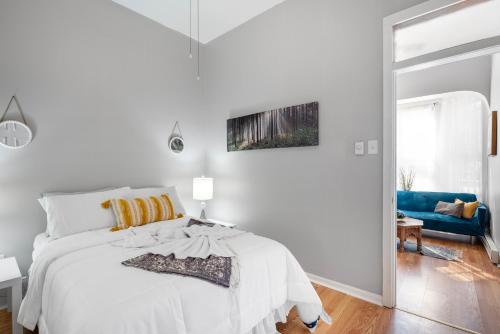 a white bedroom with a bed and a blue couch at Charming 1br In Univ City in Philadelphia