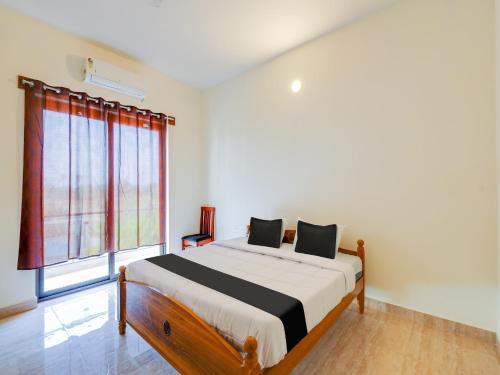 een slaapkamer met een bed en een groot raam bij Collection O Continental Bay Inn in Chennai