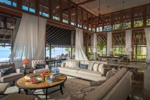 una gran sala de estar con sofás y una mesa. en Four Seasons Resort Langkawi, en Tanjung Rhu