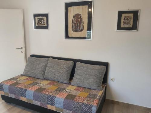 um quarto com uma cama com duas almofadas e fotografias na parede em Apartment Lara em Medulin