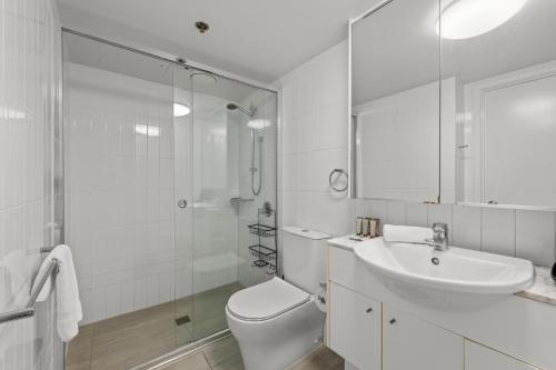 uma casa de banho branca com um WC e um lavatório em Brisbane on Felix Luxury Suites em Brisbane