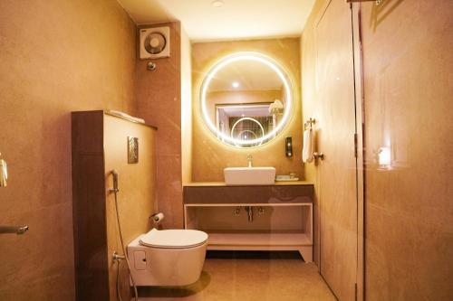uma casa de banho com um WC, um lavatório e um espelho. em ORSINO RESORT MALL ROAD em Darjeeling