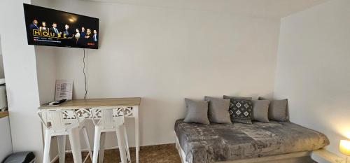 a bedroom with a bed and a table and a tv at Pleasure Black Beach Perissa Santorini in Perissa