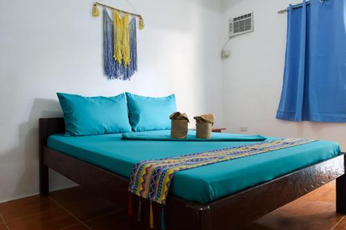 a bed in a room with two shoes on it at Garpeza Backpackers in Port Barton