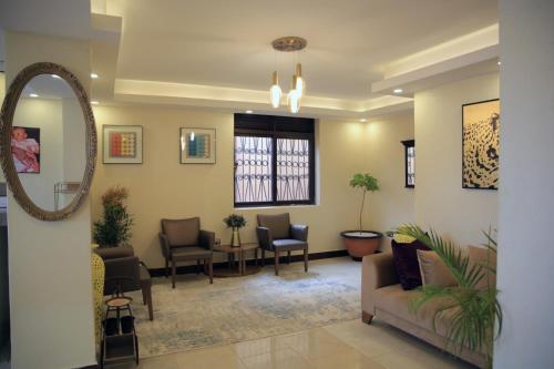 - une salle d'attente avec des chaises et un miroir dans l'établissement Enn Business Hotel, à Kampala