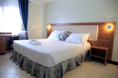 a large white bed in a hotel room at Enn Business Hotel in Kampala