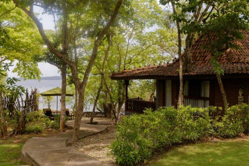 a house with a path next to a building with trees at Plataran Menjangan Resort and Spa - CHSE Certified in Banyuwedang