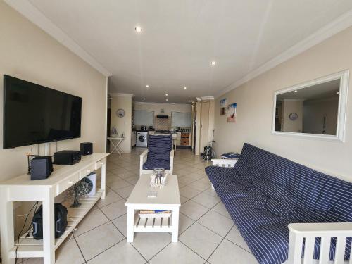 ein Wohnzimmer mit Couch und Flachbildfernseher in der Unterkunft Coastal Getaway in Jeffreys Bay