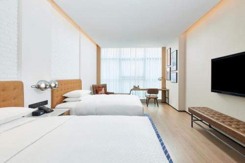 een hotelkamer met 2 bedden en een flatscreen-tv bij Four Points by Sheraton Xi’an High-Tech Zone in Xi'an