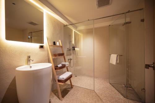 a bathroom with a sink and a glass shower at 宜蘭東旅 in Yilan City