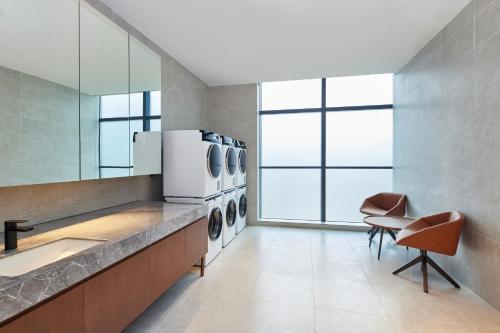 a laundry room with a counter with washing machines at Four Points by Sheraton Xi’an High-Tech Zone in Xi'an