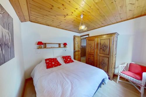 een slaapkamer met een wit bed met rode kussens bij CASA-La Carotto Apart in chalet Saint Veran in Saint-Véran