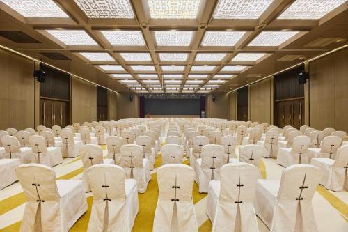 a large room filled with white chairs and a stage at Four Points by Sheraton Xi’an High-Tech Zone in Xi'an