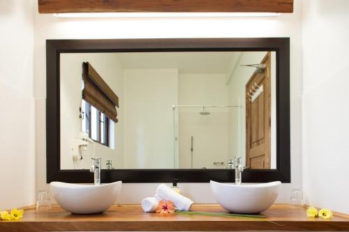 a bathroom with two sinks and a large mirror at L'Hirondelle Self Catering Guest House in Anse Possession