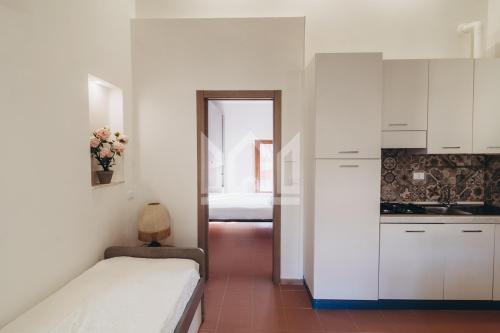 a bedroom with a bed and a kitchen with white cabinets at Gold Palace ***** in Ferrara