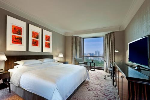シンガポールにあるSheraton Towers Singapore Hotelの大型ベッドとテレビが備わるホテルルームです。
