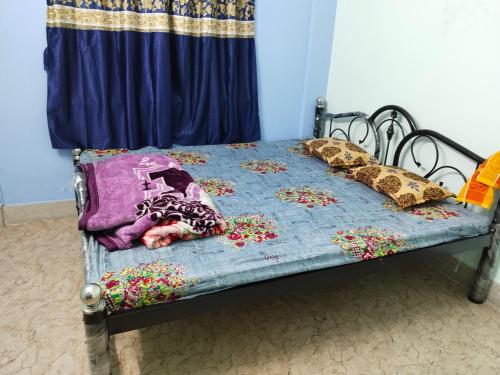 a toddler sleeping on a bed with flowers on it at Behala home stay in Kolkata