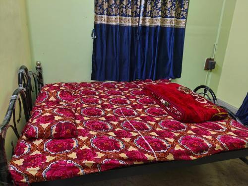 a bed with a bedspread with roses on it at Behala home stay in Kolkata
