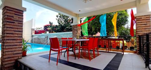 a patio with a table and chairs and a pool at Bountiful Inn in Puerto Princesa City