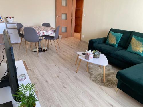 een woonkamer met een groene bank en een tafel bij City Apartment in Piešťany