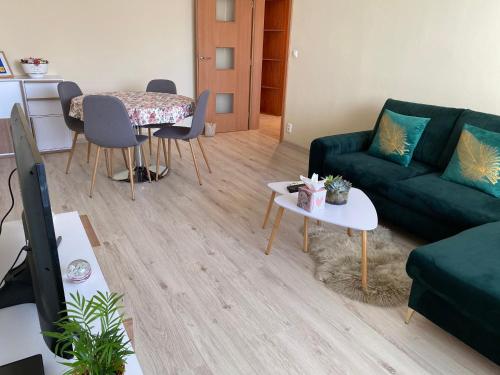 a living room with a green couch and a table at City Apartment in Piešťany
