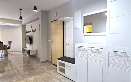 a kitchen with white cabinets and a desk in a room at VIP Apartamenty Stara Polana 2 in Zakopane