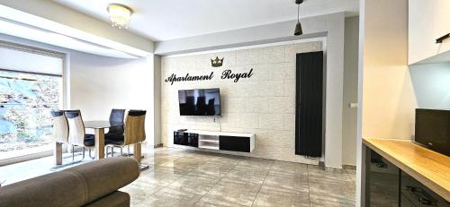 a living room with a couch and a tv on a wall at VIP Apartamenty Stara Polana 2 in Zakopane