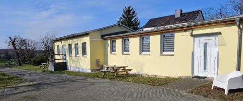 a yellow building with a picnic table in front of it at Gästewohnung Heinrich Heine Schule in Bad Dürrenberg