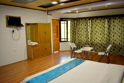 a bedroom with a bed and a television in a room at Hotel Rangyul in Kargil