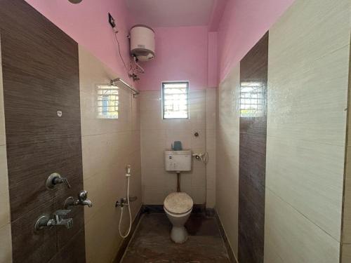 a bathroom with a toilet and a pink ceiling at Corridor Homestay in Sainj