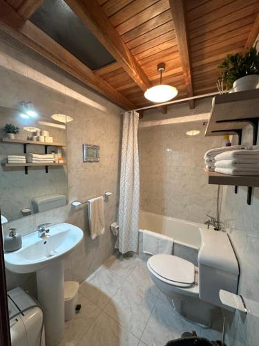 La salle de bains est pourvue d'un lavabo, de toilettes et d'une baignoire. dans l'établissement Cuberto da Parrula, à Muros