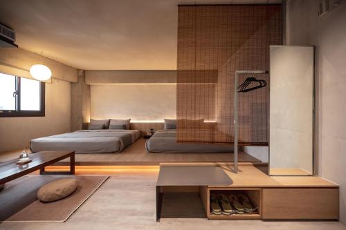 1 dormitorio con 2 camas y mesa en 宜蘭東旅, en Yilan City