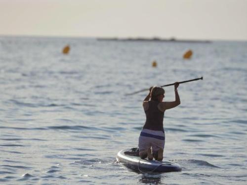a woman on a paddle board in the water at La Jabotte in Antibes