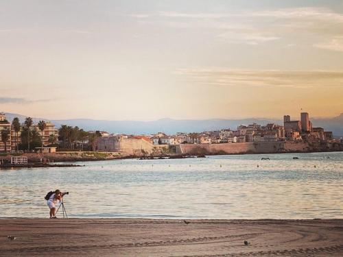 a person taking a picture of the water on the beach at La Jabotte in Antibes