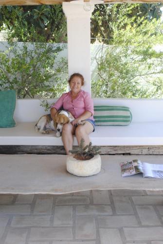 une femme assise sur un porche avec un chien dans l'établissement Monte das Cortelhas, à Guia