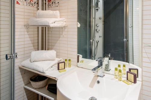 une salle de bain avec un lavabo, un miroir et des serviettes dans l'établissement Amazing studio on the most prestigious street, à Paris