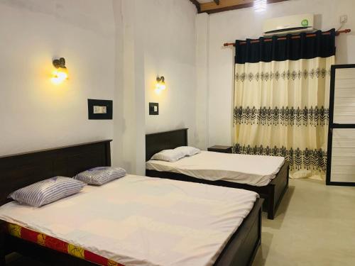 a room with two beds and a window at Shehan Villa in Beruwala
