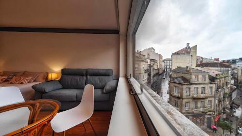 a living room with a couch and a large window at Centro Vigo Estudio Puerta del Sol in Vigo