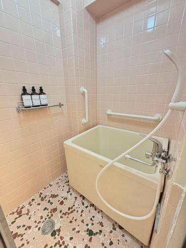 a bathroom with a bath tub in a room at Neighbor's Hotel 広島駅北口 in Hiroshima