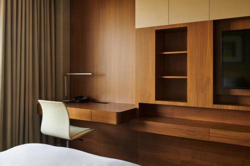 a bedroom with a desk and a chair and a tv at Hotel Hyundai by Lahan Ulsan in Ulsan