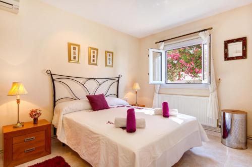 ein Schlafzimmer mit großem Bett und Fenster in der Unterkunft Villa Serena by Mauter Villas in Cala en Porter