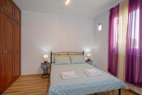 a bedroom with a bed with two towels on it at Thalassa Home Comfort in Petra