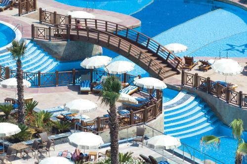 an overhead view of a pool with chairs and umbrellas at Fame Residence Lara & Spa in Lara
