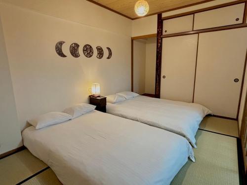 two beds sitting next to each other in a room at Neighbor's Hotel 広島駅北口 in Hiroshima