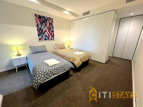 - une chambre avec 2 lits et un tableau mural dans l'établissement Nice in New Acton - 2bd 2bth Apt, à Canberra