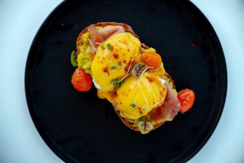 un piatto nero con un uovo su una fetta di pane tostato di Adiwana Warnakali Resort a Nusa Penida