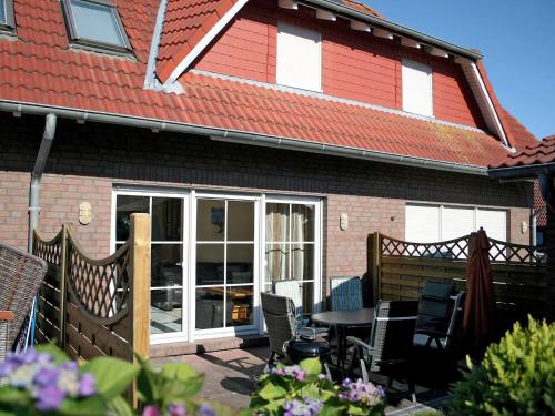 a house with a patio with a table and chairs at Ferienhaus Schulte in Carolinensiel
