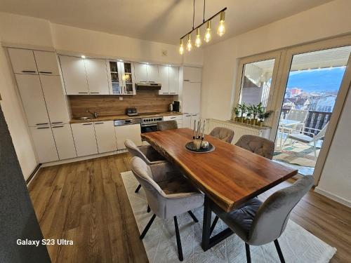 een keuken en eetkamer met een houten tafel en stoelen bij Apartment City View in Bihać