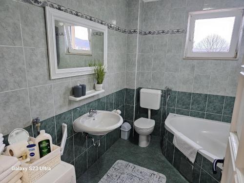 een badkamer met een wastafel, een toilet en een bad bij Apartment City View in Bihać
