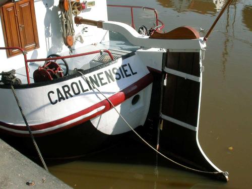 una barca legata a un molo in acqua di Ferienwohnung Brinkmann a Carolinensiel